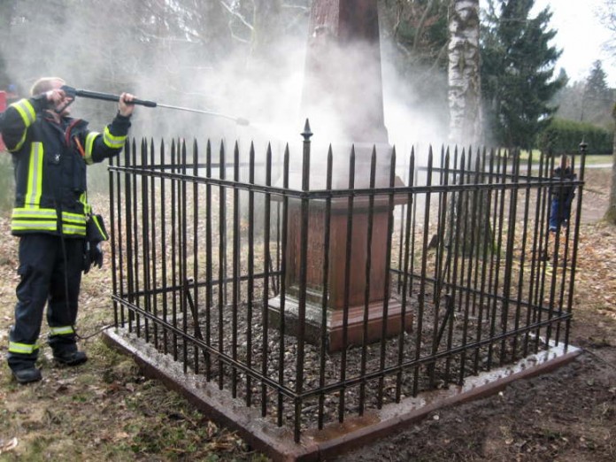 Der stellv. Jugendwart Dominik Tröster reinigt das Denkmal mit Hilfe des Hochdruckreinigers.